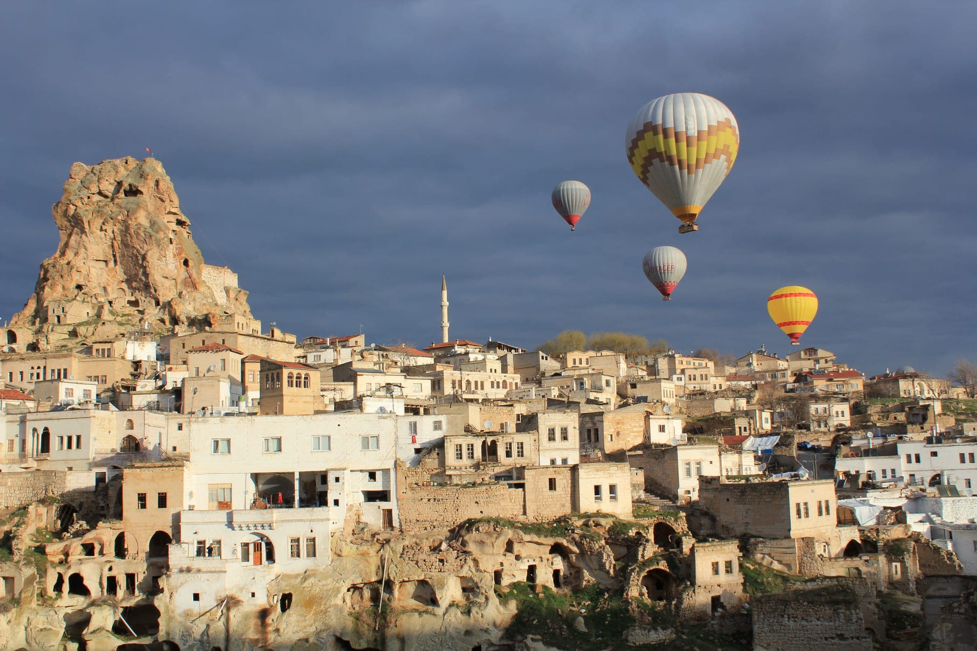 Hot air balloons drifting over Ortahisar castle in Cappadocia